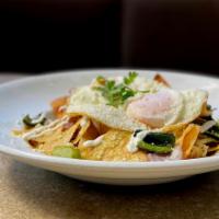 Chilaquiles Breakfast · 2 eggs over easy, sauteed poblano and onions, black beans, grilled onions, queso fresco, cre...