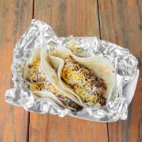 TJ's Tacos  · 2 flour tortillas filled with chopped brisket, sauce and grated cheese. Simply delicious!