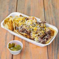 Carlton's Nachos  · A pile of corn tortilla chips topped with queso, chopped brisket, sauce, and grated cheese. ...