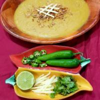 Chicken Haleem · Lentils and shredded chicken slow cooked and garnished with lemon, ginger, and fried onions.