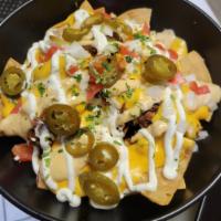 Chicken Nachos · House Chips Topped with Chicken Fajita, Black Beans, Homemade Queso, Sour Cream, Chipotle Sa...