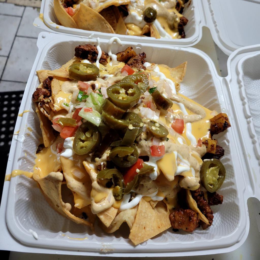 Chorizo Nachos · House Chips Topped with Grilled Chorizo, Black Beans, Homemade Queso, Sour Cream, Chipotle Sauce, Pickled Jalapeños, and Pico 
