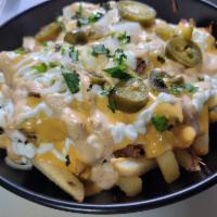 Carnitas Mexi Fries · Topped with roasted pulled pork carnitas, homemade queso, sour cream, chipotle sauce, pickle...