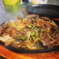 Lomo Salteado · marinated strips of sirloin (or other beef steak) with onions, tomatoes, french fries,
