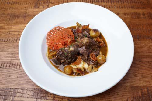 Coq Au Vin · A classic French dish of Burgundy braised chicken with pancetta, mushrooms, and pearl onions, served with pommel mousseline
