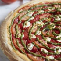Margherita Pizza · Served with pizza sauce, tomatoes, fresh mozzarella and topped with basil pesto sauce.