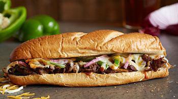 Philly Cheesesteak · Loaded with Philly meat, green peppers, red onions and a mix of Wisconsin cheese blend and cheddar.