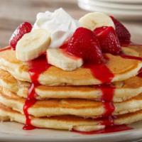 Strawberry Pancakes · 4 buttermilk pancakes with banana slices inside and bathed in strawberries with bananas whip...