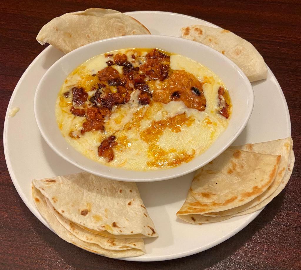 Queso Fundido · Melted Muenster cheese with spicy Mexican sausage, topped with pico de gallo and served with flour tortillas.