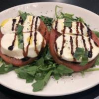 Caprese Salad · Fresh mozzarella, heirloom tomatoes and basil on a bed of arugula with a balsamic drizzle.