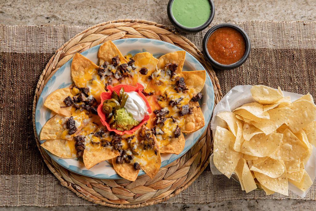 Fajita Nachos · Your choice of beef, chicken, or combo fajita, served with refried beans, melted cheese, guacamole, sour cream and jalapenos.