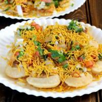 Sev Puri · Flattened puris serve as the base with topping of potatoes, chutneys and garnished with sev.