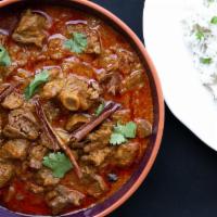 Handi Goat Curry · Tender goat cooked in Handi-style curry sauce. Comes with basmati rice on the side.