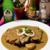 Chuletas en Salsa Verde O Roja · Pork chops in green or red sauce served with rice and beans, and tortillas or bread.