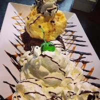 Brownie Delight · Warm brownie topped with vanilla ice cream, caramel and chocolate syrup. 