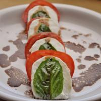Mozzarella with Tomatoes · Mozzarella, sliced tomatoes, topped with basil and olive oil.