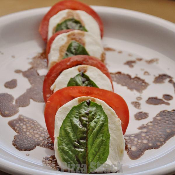 Mozzarella with Tomatoes · Mozzarella, sliced tomatoes, topped with basil and olive oil.