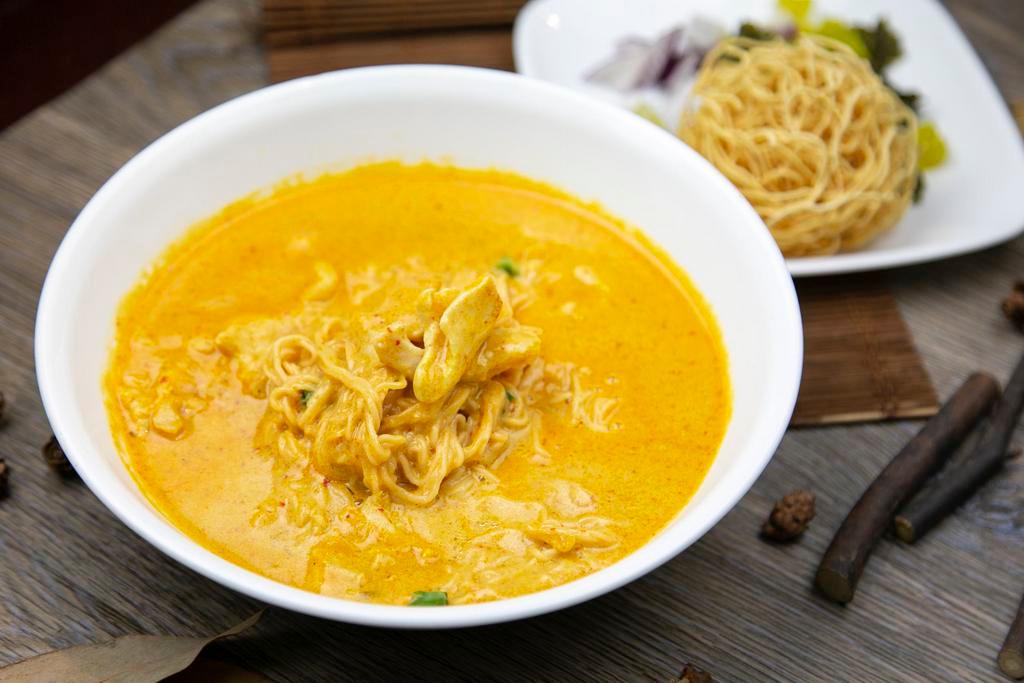 Khao-Soy · Rich yellow curry, crispy egg noodles, mustard greens, red onions & lime