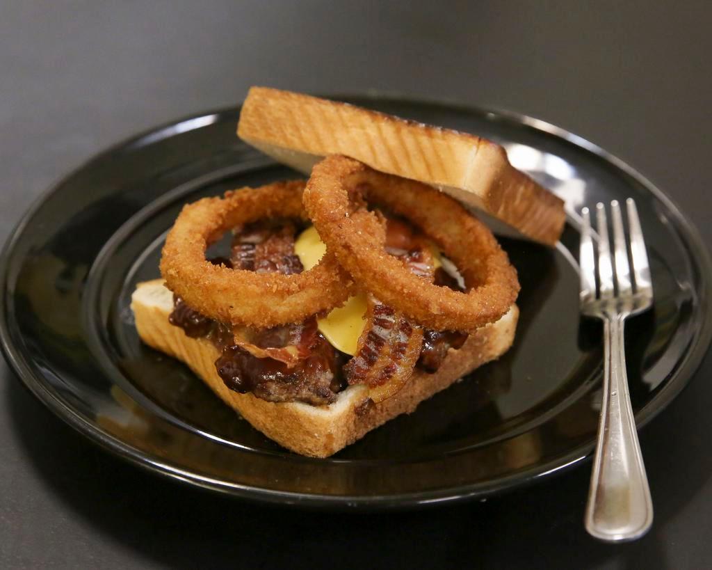 Steak Sandwich · Grilled beef tenderloin, fried onion rings and house steak sauce. Served with fries.