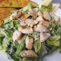 Chicken Caesar Salad · Crisp romaine greens, topped with sliced chicken breast, croutons, Parmesan cheese and our o...