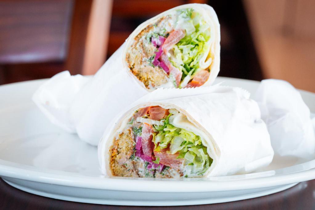 Fal. Sandwich · falafel patties wrapped 
in pita bread with lettuce, tomatoes, 
pickled turnips and tahini sauce.
