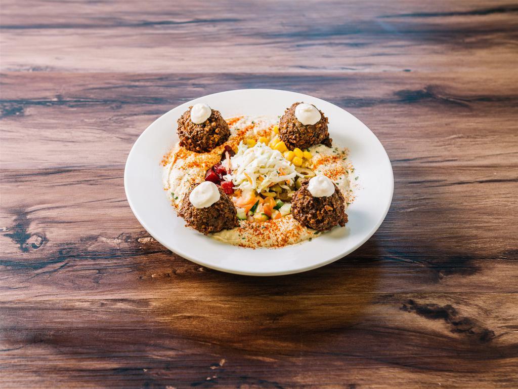 Falafel Plate · 4 falafel balls on a bed of hummus, topped with oil, paprika and toppings of your choice. Includes pita and tahini on side.