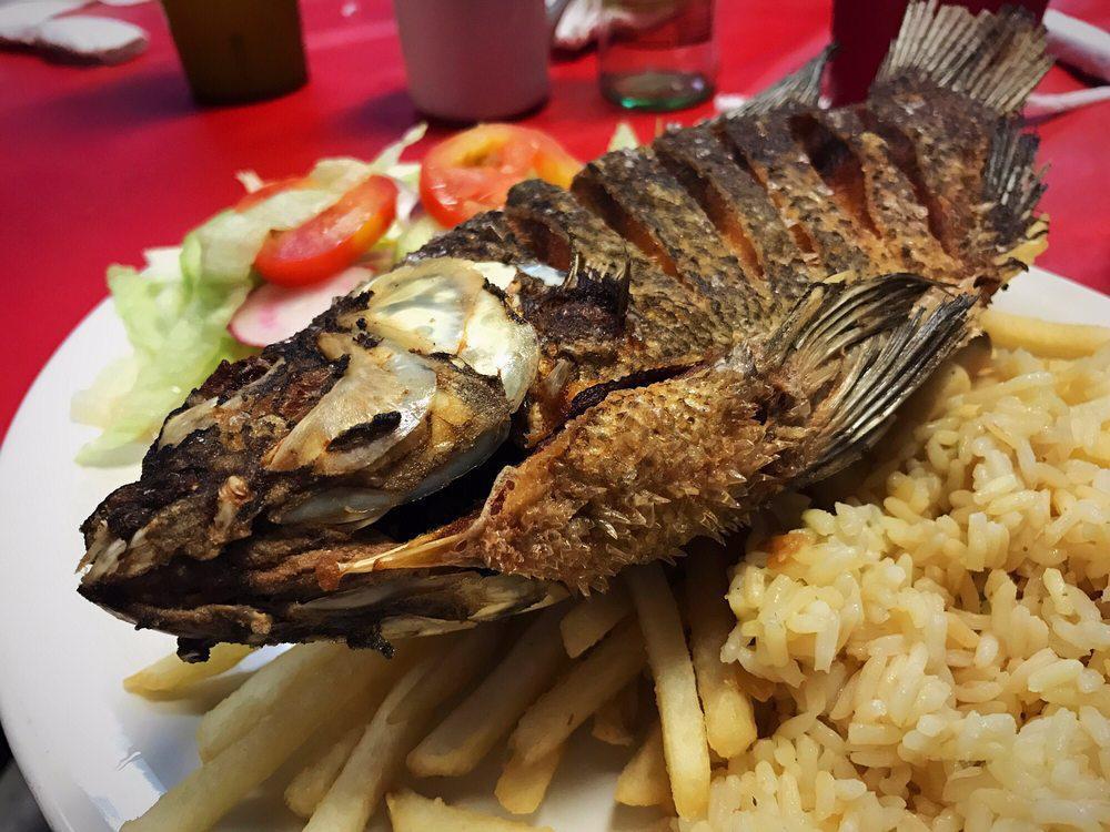 Fried Fish · Pescado frito. Tilapia served with beans, rice, and salad.