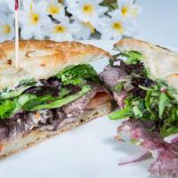 Con Amor Steak Sandwich · Marinated sliced steak with roasted garlic, lettuce, red onion and chipotle mayo. Served on ...