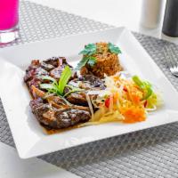 Oxtail Dinner · Oxtail served with Rice and Peas or White Rice, Steamed Cabbage and Plantains