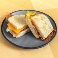 Breakfast Sandwich · 2 eggs, choice of bacon sausage or ham, cheddar cheese, on sourdough or wheat bread. 
