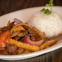 Lomo Saltado · Top sirloin strips in soy-based marinade, sauteed with tomato, onions, fries, and accompanie...