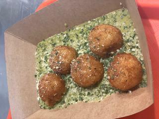 Risotto Arancini · Mushroom risotto made with roasted veggie stock, white truffle oil, and parmesan, rolled into balls, breaded and fried, on top of our house Rosie pesto sauce
