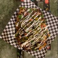 Nachos · Homemade potato chips, smothered in our homemade queso, topped with lettuce sour cream and t...
