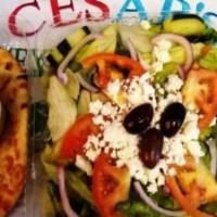 #65. Greek Salad · Lettuce, onions, tomatoes, cucumbers, Kalamata olives, feta cheese, pita with Cesar’s Greek ...