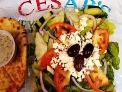 #65. Greek Salad · Lettuce, onions, tomatoes, cucumbers, Kalamata olives, feta cheese, pita with Cesar’s Greek dressing.