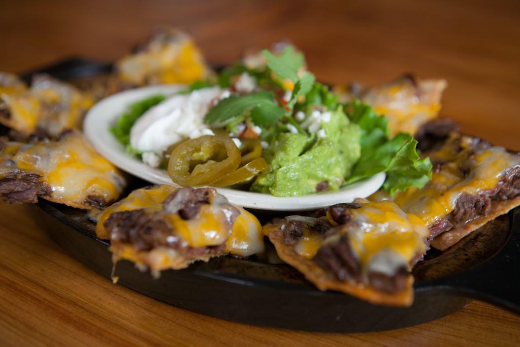 Nachos · 8 wedges topped off with your choice of beef or chicken fajitas, beans and melted cheese blend. Served with guacamole, pico de gallo and sour cream. 