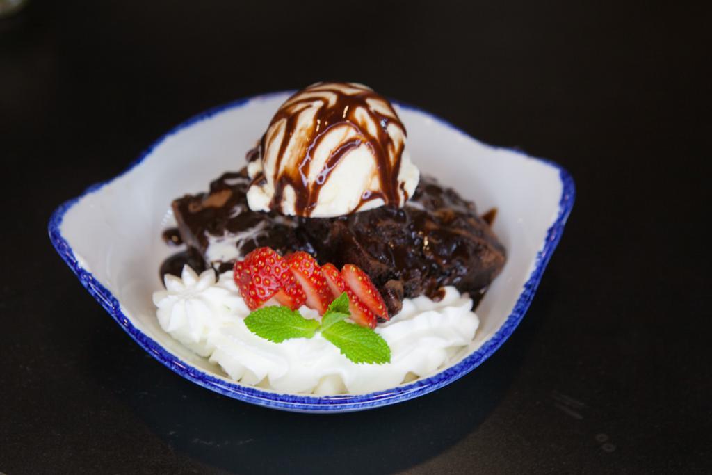 Agave Brownie · Texas size chocolate brownies topped off with vanilla ice cream and served with fresh fruit, home made whipped cream and chocolate sauce. 