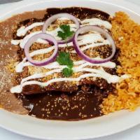 Emoladas (enchiladas with mole sauce) · 3 corn tortillas with your choice of filling and topped with mole sauce, cheese, and sour cr...