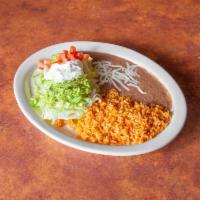 27. Burrito Supreme Specialty · Flour tortilla rolled around beef, cheese, topped with lettuce and sour cream. Served with r...