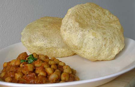 Chole Bhatura · Chickpea curry made with tomato, onion, Thai chilies, garlic, cashew and Indian spices, topped with fresh cut onion, cilantro leaves and served with fried Indian flatbread.