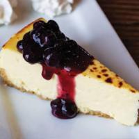 Blueberry Creme Brulee Cheesecake · Light and delicate cheesecake with a hand-fired top layer of creme brulee, served with a blu...