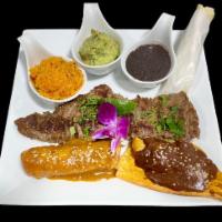 Carne Asada a la Tampiquena · Beef tenderloin strip steak marinated in lime and herbs served alongside a chicken taquito i...