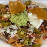 Mexican Nachos · Choice of meat, with beans, tomatoes, onions, jalapenos, sour cream, and guacamole.