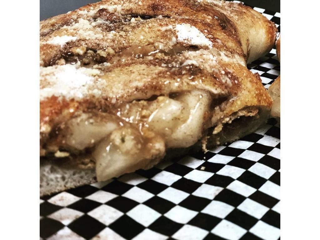 Apple Pie Calzone · Folded dough filled with apple pie filling and graham cracker. Topped with cinnamon butter and graham cracker crumble.
