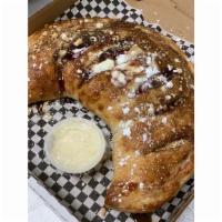Blueberry Cheescake Calzone · Folded dough filled with cheesecake filling, blueberry pie filling and graham crackers, topp...