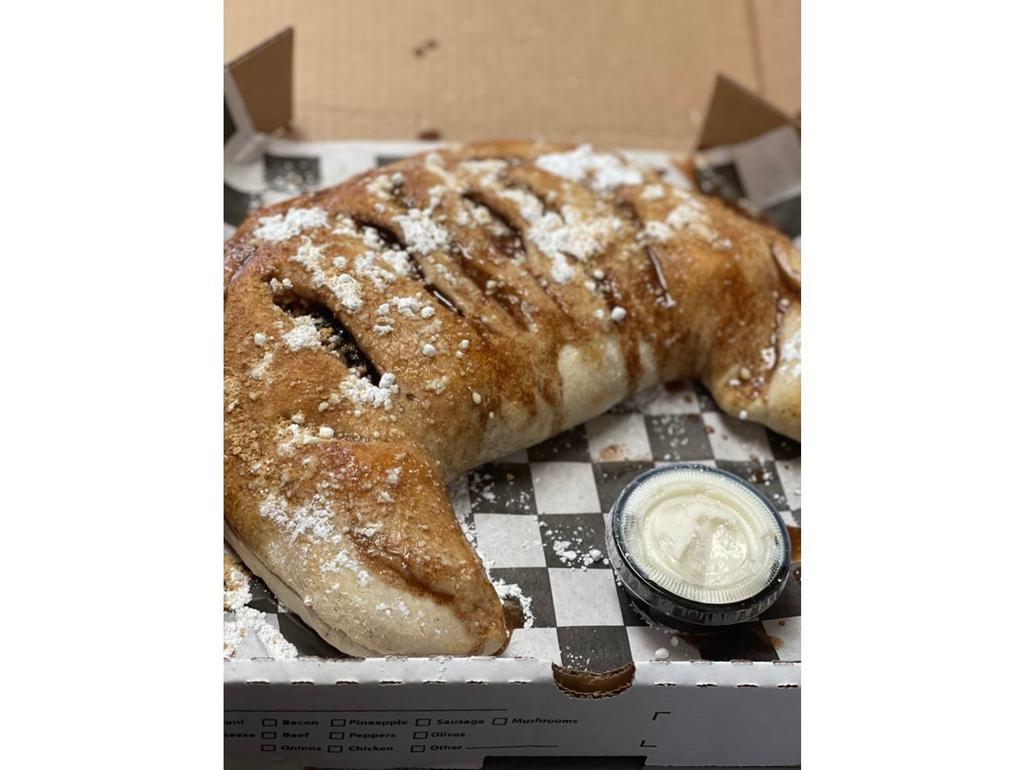 Blueberry Pie Calzone · Folded dough filled with blueberry pie filling and graham crackers. Topped with cinnamon butter and graham cracker crumbles