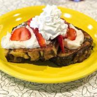 Cinnamon Roll French Toast Sweets · Two slices of grilled cinnamon french toast topped with seasonal fruit, buttercream icing, w...