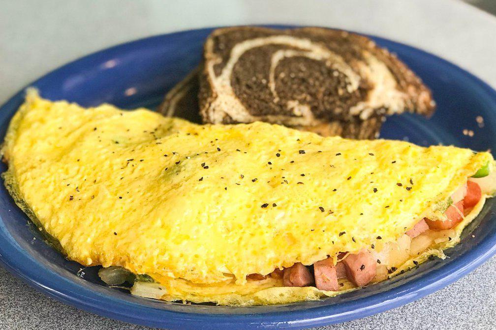 Western Omelet. · Three egg omelet filled with sauteed tomatoes, yellow onions, green peppers, ham, melted swiss and cheddar cheeses. Served with your choice of toast.