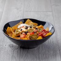 Beef Nachos · Tortilla chips piled high with jalapeсos, black beans, tomatos and mixed cheese sauce and be...