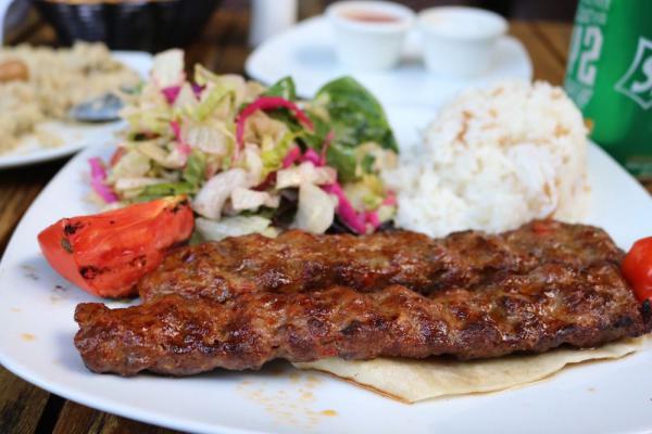 Lamb Adana Kebab · Ground lamb flavored with red bell peppers, slightly seasoned with paprika and grilled on skewers. Served salad and rice.